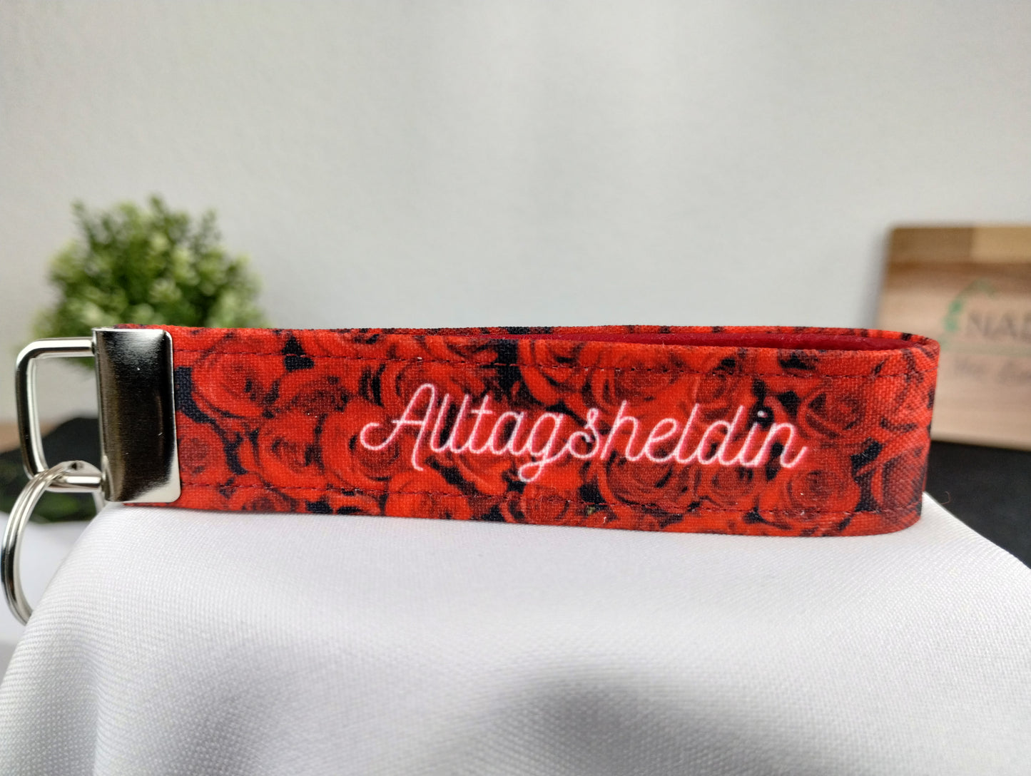 Personalisierbarer Schlüsselanhänger mit roten Rosen, weißer Schrift und innen mit rotem Filz