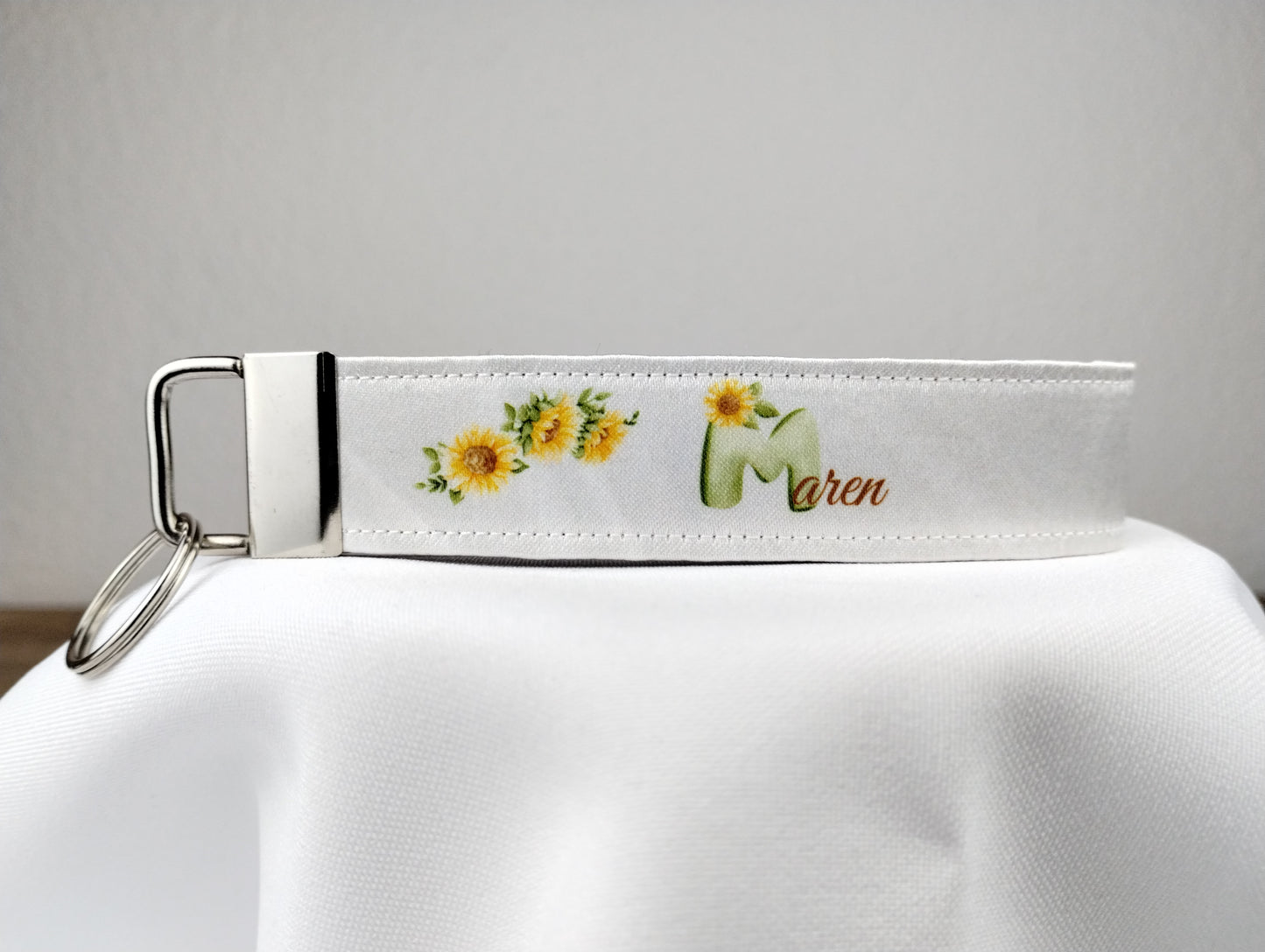 personalisierbarer Schlüsselanhänger Gartengaudi mit weißem Hintergrund und Sonnenblumenmotiven 