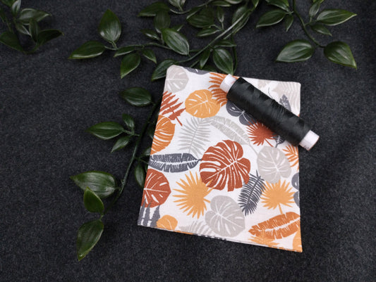 Duftkissen mit vielen verschiedenen Blättern in braun, orange und grau auf weißem Hintergrund. Vernäht wird das Kissen mit einem dunkelgrauen Nähgarn
