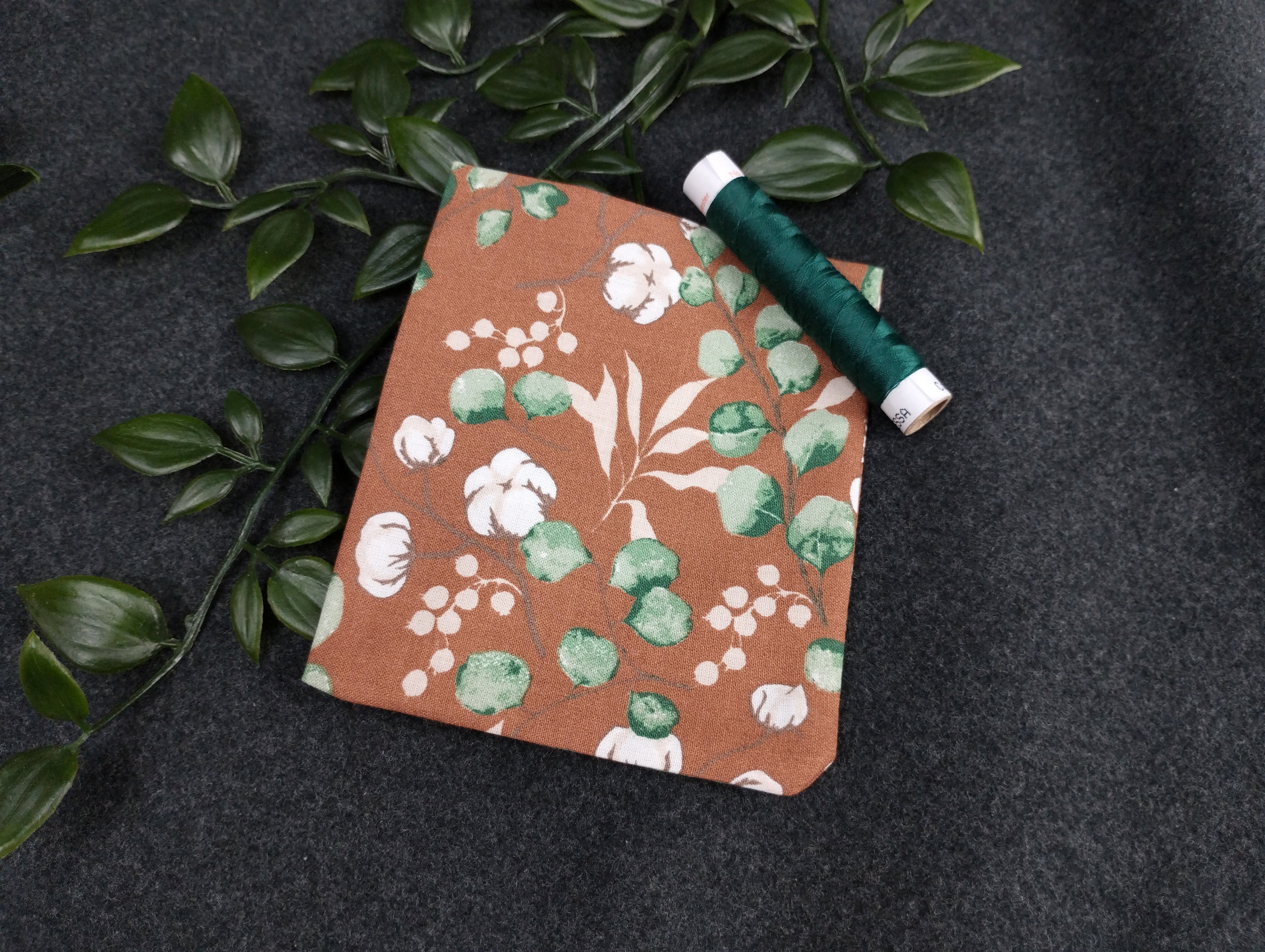 Duftkissen mit einem Eucalyptus/Baumwollmotiv in braun. Vernäht mit einem dunkelgrünen Nähgarn.