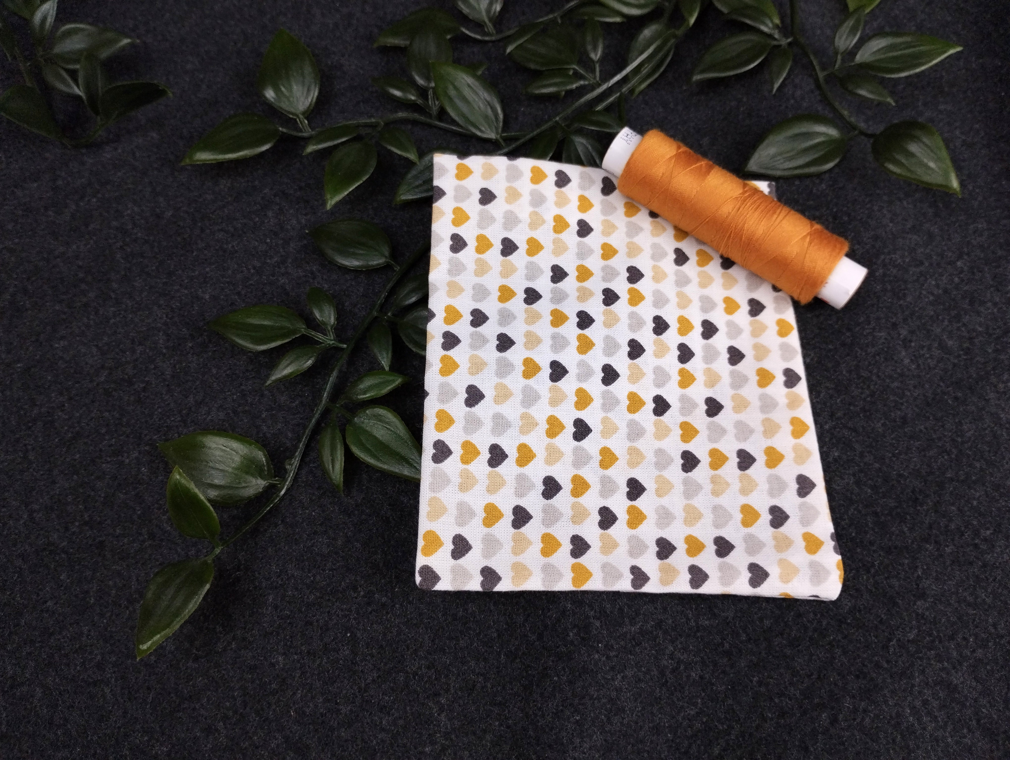 Duftkissen mit vielen kleinen Herzen in grau, schwarz, beige und ocker. Vernäht wird es mit einem passenden Nähgarn