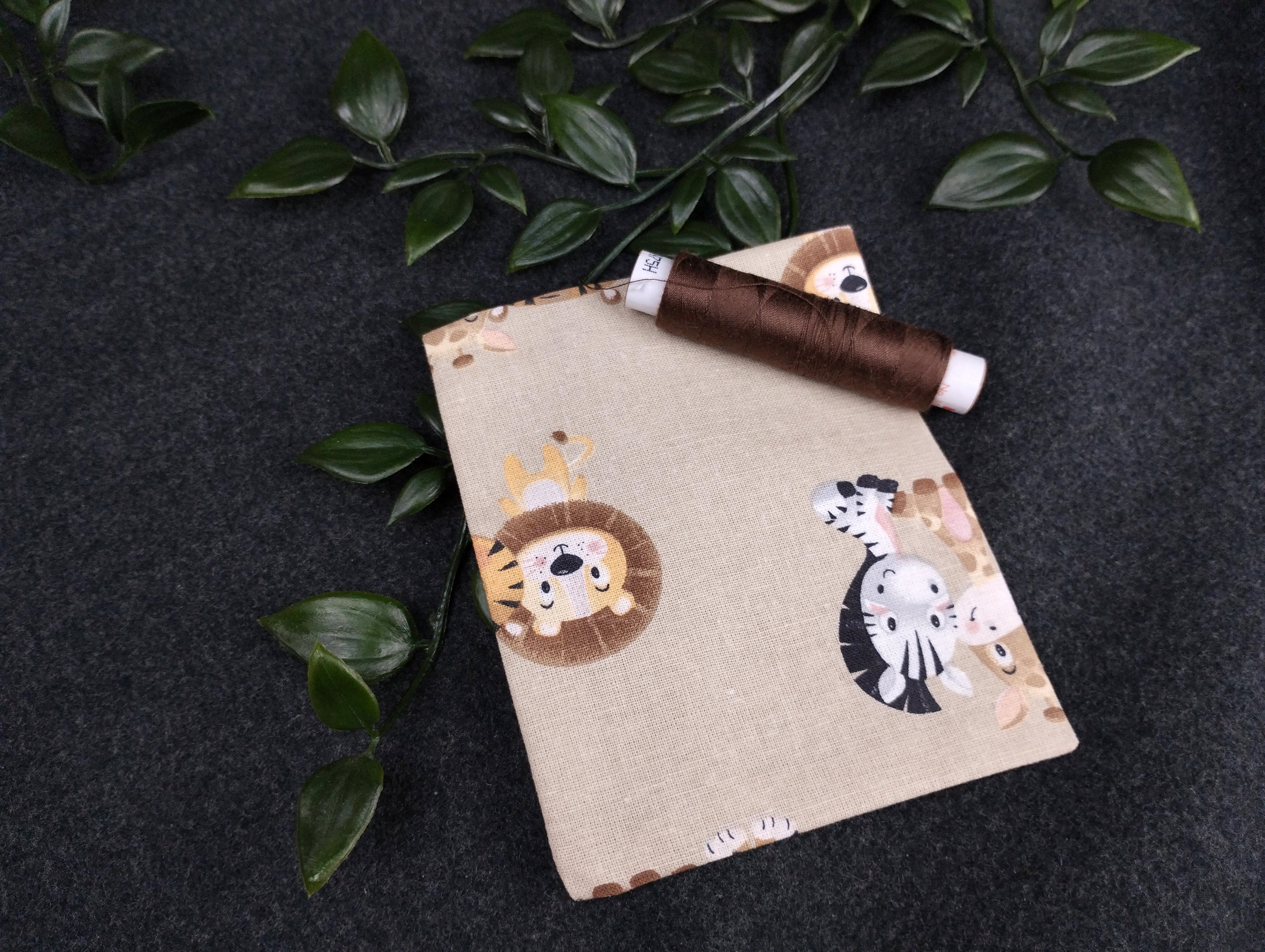 Duftkissen mit niedlichen Zootieren auf beigem Hintergrund. Vernäht mit einem dunkelbraunem Nähgarn.