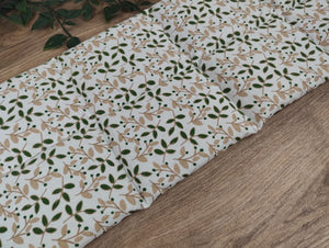 weißes Körnerkissen in der Größe 50*20cm mit grünen Blättern und beigefarbenen Zweigen