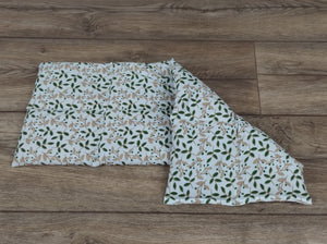 weißes Körnerkissen in der Größe 50*20cm mit grünen Blättern und beigefarbenen Zweigen