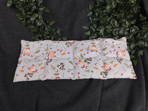 Körnerkissen mit Fuchs und Waschbärmotiv und blaugrauem Hintergrund.