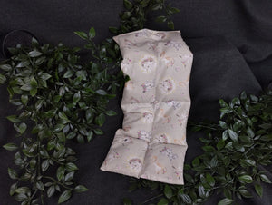 Körnerkissen in grau mit niedlichen Tierbabys im Vordergrund. Verziert mit kleinen Blümchen