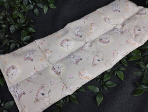 Körnerkissen in grau mit niedlichen Tierbabys im Vordergrund. Verziert mit kleinen Blümchen