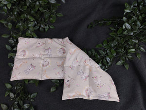 Körnerkissen in grau mit niedlichen Tierbabys im Vordergrund. Verziert mit kleinen Blümchen