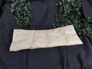 personalisiertes Körnerkissen mit dem Namen Angelina. Das Hauptmotiv in beige mit weißen Ranken und der Name weiß gestickt auf beigem Stoff.