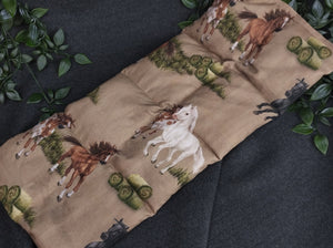 Körnerkissen mit Pferden und Heuballen im Vordergrund