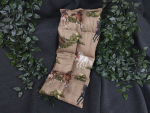 Körnerkissen mit Pferden und Heuballen im Vordergrund