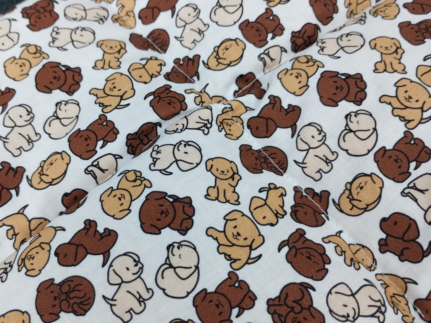 Nahaufnahme unseres Körnerkissens mit niedlichen Labradorwelpen als Motiv.