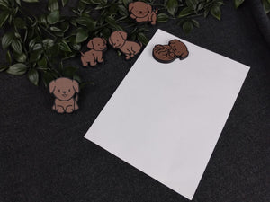 Dunkelbraune Labrador Welpenmagnete am Beispiel eines DIN A5 Blattes.