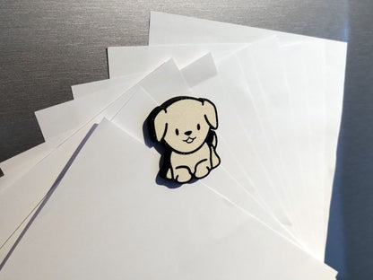 Beispiel eines cremefarbenen Labrador Welpen Kühlschrankmagneten, der 10 DIN A5 Zettel hält.