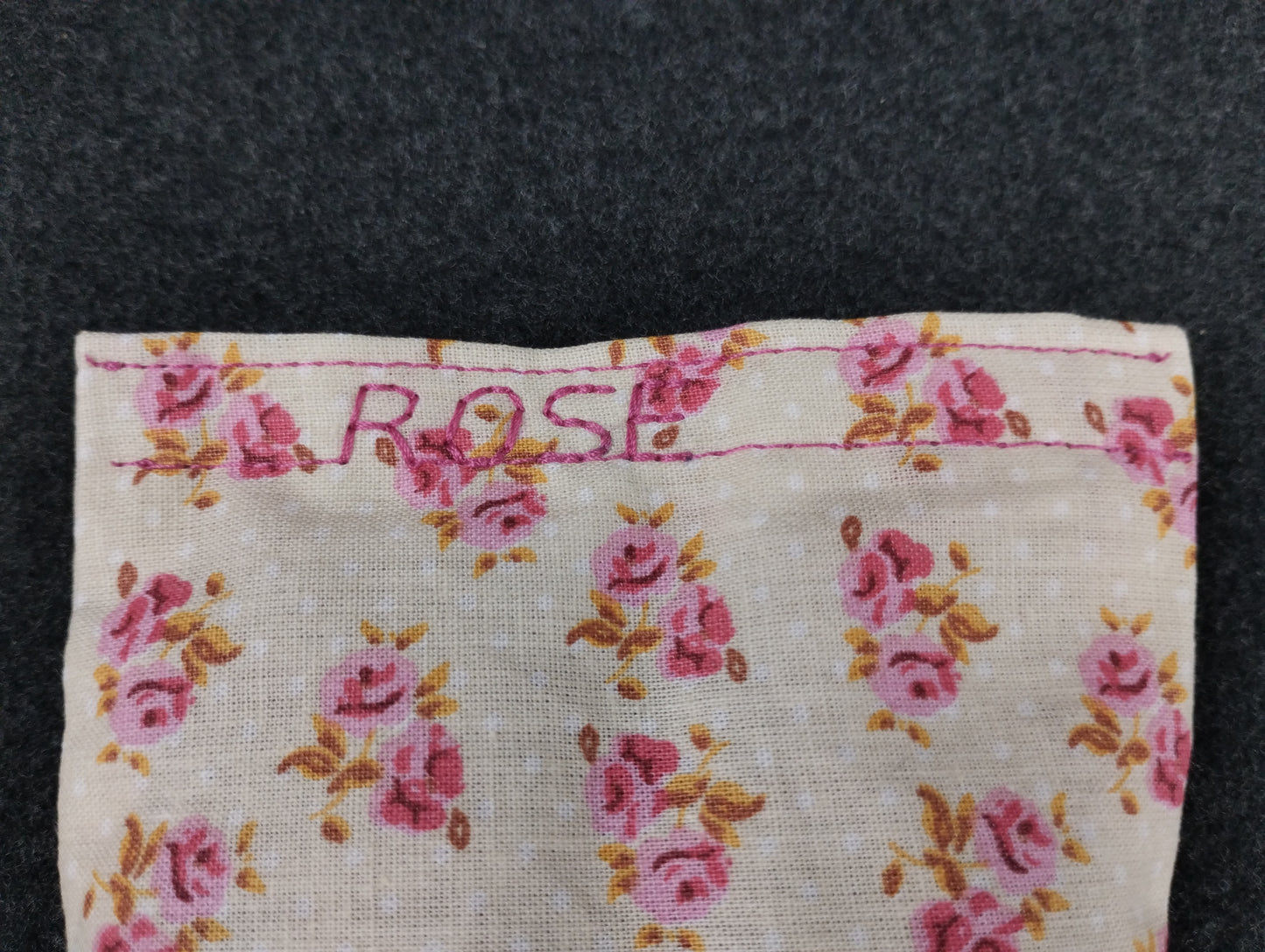 fertiges Duftkissen mit kleinen rosa Rosen auf beigem Hintergrund. Personalisiert mit dem Wort ROSE in rosa