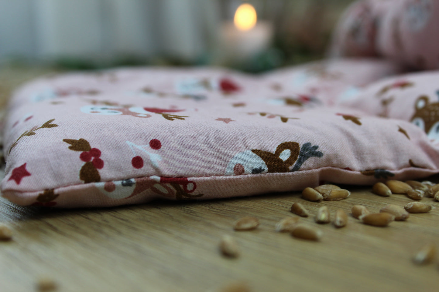 weihnachtliches Körnerkissen in rosa mit niedlichen Rentierköpfen und Weihnachtsmütze
