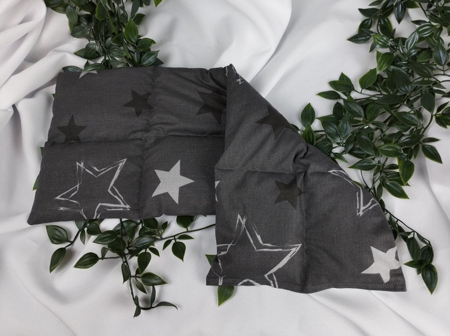 Körnerkissen mit Sternenmotiv auf dunkelgrauem Hintergrund