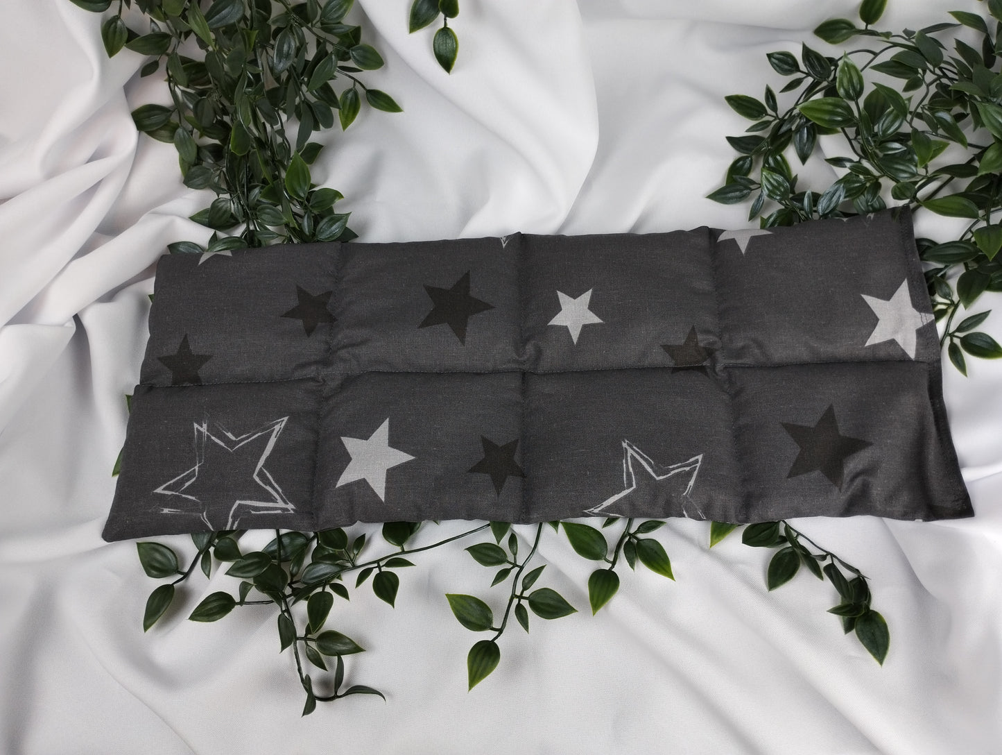 Körnerkissen mit Sternenmotiv auf dunkelgrauem Hintergrund